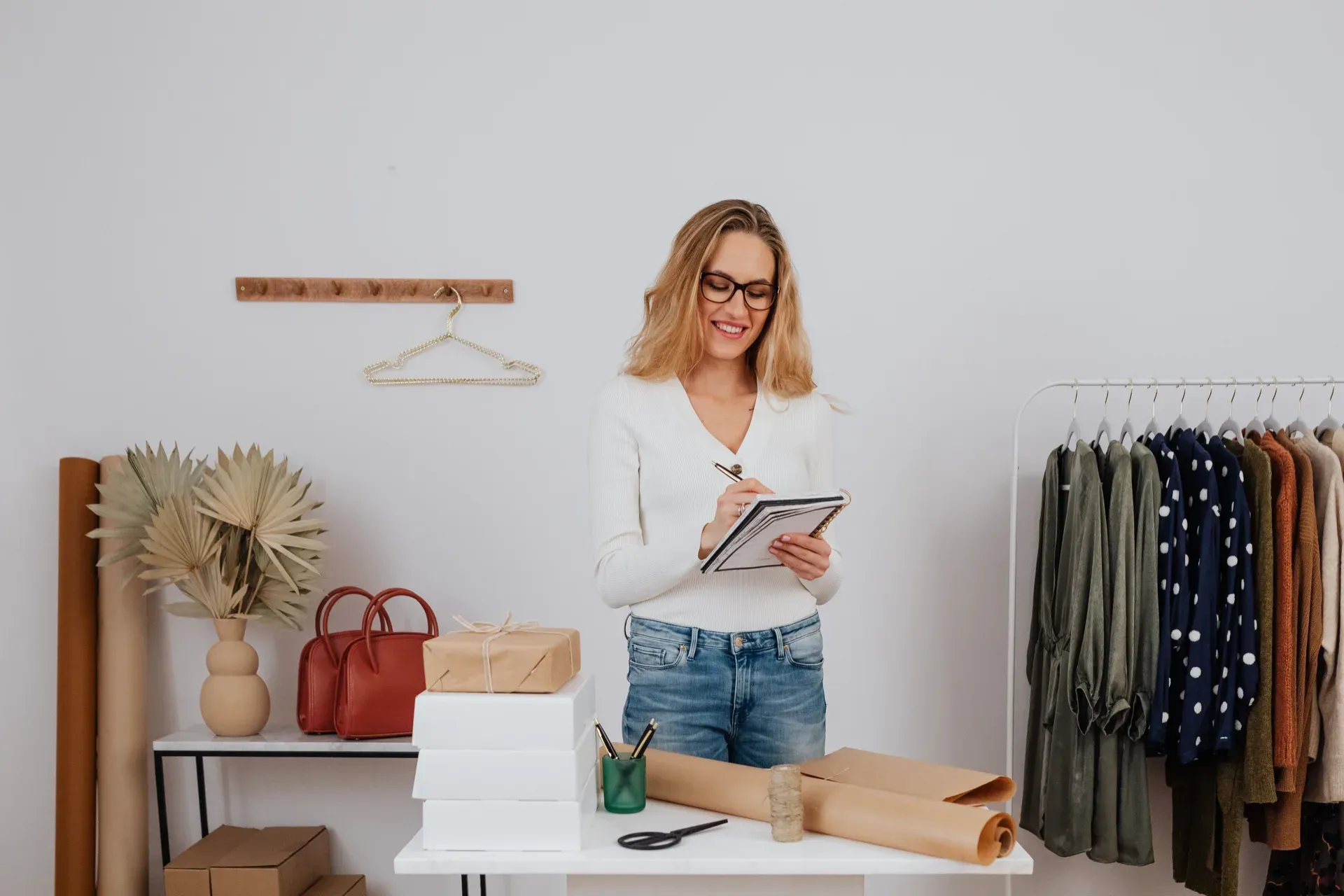 A store owner reviewing a checklist while packing orders at a wrapping station
