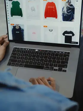 An ecommerce catalogue being worked through on a laptop, product tiles filling the screen.